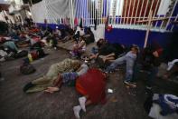 Migrants, mostly from Central America, sleep-in on the street in Huixtla, Chiapas state, Mexico, at daybreak Tuesday, Oct. 26, 2021, as they use the day to rest during their trek by foot toward the U.S. (AP Photo/Marco Ugarte)