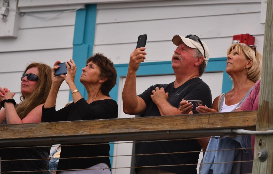 People line the Westgate Cocoa Beach Pier to watch the April 28, 2023, launch of a SpaceX Falcon 9 rocket and two communications satellites from launch Complex 40 at Cape Canaveral Space Force Station.