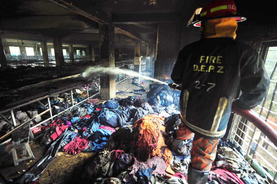 A firefighter douses the inside of a garment factory outside Dhaka, Bangladesh, Sunday, Nov. 25, 2012. At least 112 people were killed in a late Saturday night fire that raced through the multi-story garment factory just outside of Bangladesh's capital, an official said Sunday. (AP Photo/ khurshed Rinku)