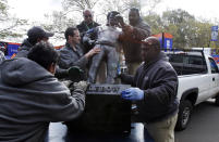 The bronze sculpture of Fred Lebow, the founder of the New York City Marathon, is unloaded by members of the Central Park Conservancy at the marathon finish line, in New York's Central Park, Friday, Nov. 2, 2012. The course for Sunday's New York City Marathon will be the same since there was little damage but getting to the finish line could still be an adventure for runners from outlying areas. Such is life in Sandy's aftermath disrupted trains, planes, buses and ferries, flooded buildings, blocked roads and knocked out power. (AP Photo/Richard Drew)