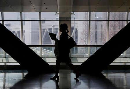 A female job seeker walks as she attends a job fair held for fresh graduates in Tokyo, Japan, March 20, 2016. REUTERS/Yuya Shino/File Photo