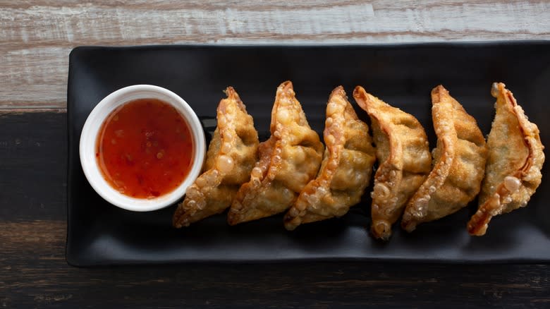 Plate of fried jiaozi with dipping sauce from above