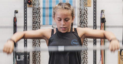 Hadley Parsons pumps iron during training  in early June at Bartlesville's Pure Health Performance in preparation for the weightlifting nationals held last weekend in Las Vegas. Parsons finished second in the nation — among approximately 30 girls — in the snatch, clean and jerk and overall point total. She is a Ranch Heights student.