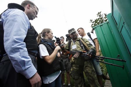 Organisation for Security and Cooperation in Europe (OSCE) monitors speak with a pro-Russian separatist (2nd R) at the crash site of Malaysia Airlines Flight MH17, near the settlement of Grabovo in the Donetsk region July 19, 2014. REUTERS/Maxim Zmeyev