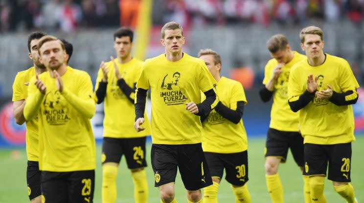 <p>Sous l’ovation des supporters allemands, et français, les joueurs du Borussia commencent leur échauffement. Ils arborent un tee-shirt en hommage à Marc Bartra, blessé par l’attaque de mardi soir. (AFP)</p>