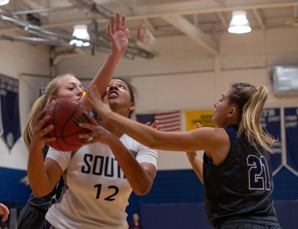 Middletown Southâ€™s Kayla Richardson tries to get an inside shot as she closely covered by Howellâ€s Caitlyn Gresko and Cassie Conte in first half action.  Girls basketball vs Middletown South in Middletown, NJ on January 22, 2019.