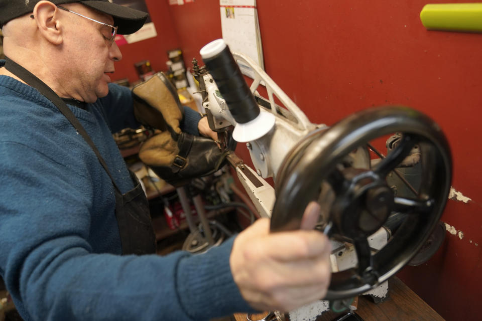 Jairo Cardenas owner the Alpha Shoe Repair Corp., works on a boot repair, Friday, Feb. 3, 2023, in New York. Business at the shop, which he’s run for 33 years, is down 75% compared with prior to the pandemic. Shoe repairs typically bring in more money than shines. (AP Photo/Mary Altaffer)