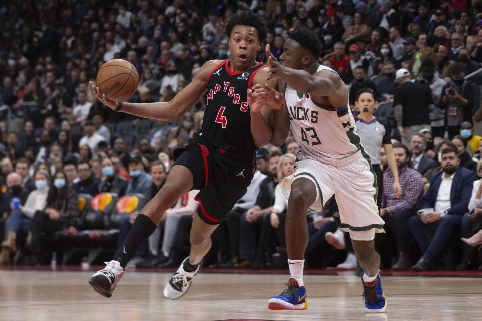 Toronto Raptors' Scottie Barnes, left, drives on Milwaukee Bucks' Thanasis Antetokounmpo during the second half of an NBA basketball game Thursday, Dec. 2, 2021, in Toronto. (Chris Young/The Canadian Press via AP)