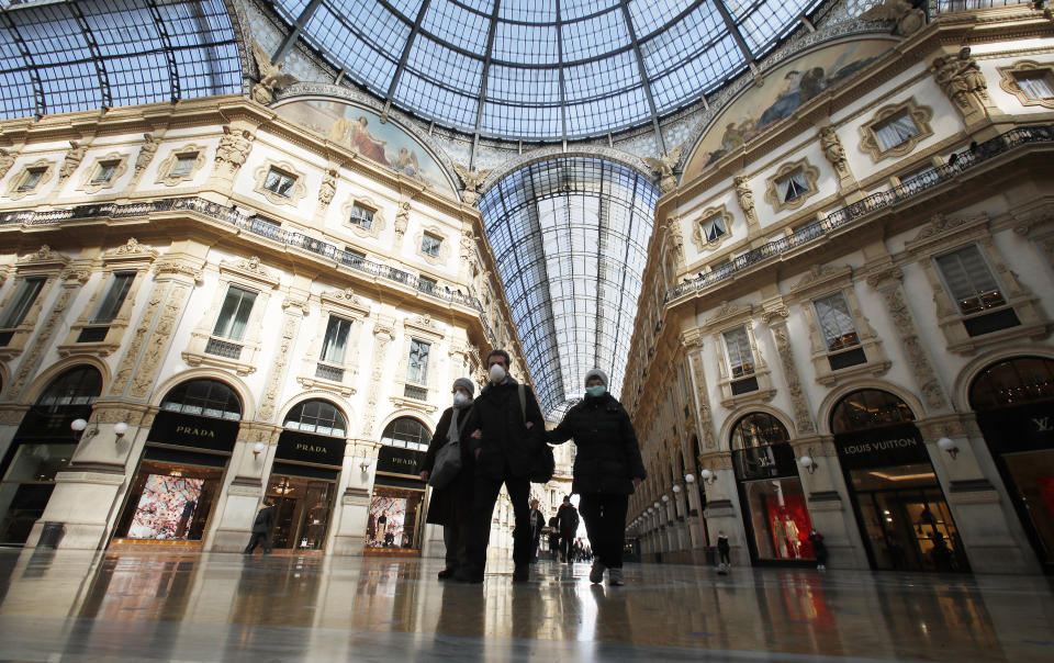 People wear masks as they walks inside Vittorio Emanuele II gallery, in downtown Milan, Italy, Sunday, March 8, 2020. Italy announced a sweeping quarantine early Sunday for its northern regions, igniting travel chaos as it restricted the movements of a quarter of its population in a bid to halt the new coronavirus' relentless march across Europe. (AP Photo/Antonio Calanni)