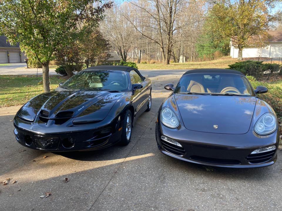 Tom Dillon has two convertibles, neither of them Mazda Miatas. He bought the 2002 black Pontiac Trans Am on the left as a retirement car the year it was made, and purchased the brown 2009 Porsche Boxster on the right a month ago after seeing it advertised for sale.