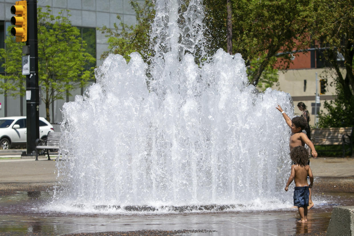 Children cool off in the Salmon Street Springs fountain in downtown Portland, Ore., as a spring heat wave sweeps across the metro area, Saturday, May 13, 2023. (Sean Meagher/The Oregonian via AP)