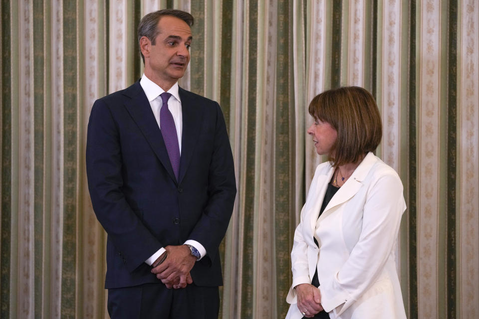 Greece's Prime Minister Kyriakos Mitsotakis, left, talks to Greek President Katerina Sakellaropoulou during his swearing in ceremony at the Presidential palace, in Athens, Greece, Monday, June 26, 2023. Greece's center-right leader Kyriakos Mitsotakis received the mandate to form a new government Monday after easily winning a second term with a record-high margin over the leftwing opposition, in an election that also ushered new far-right parties into Parliament. (AP Photo/Thanassis Stavrakis)