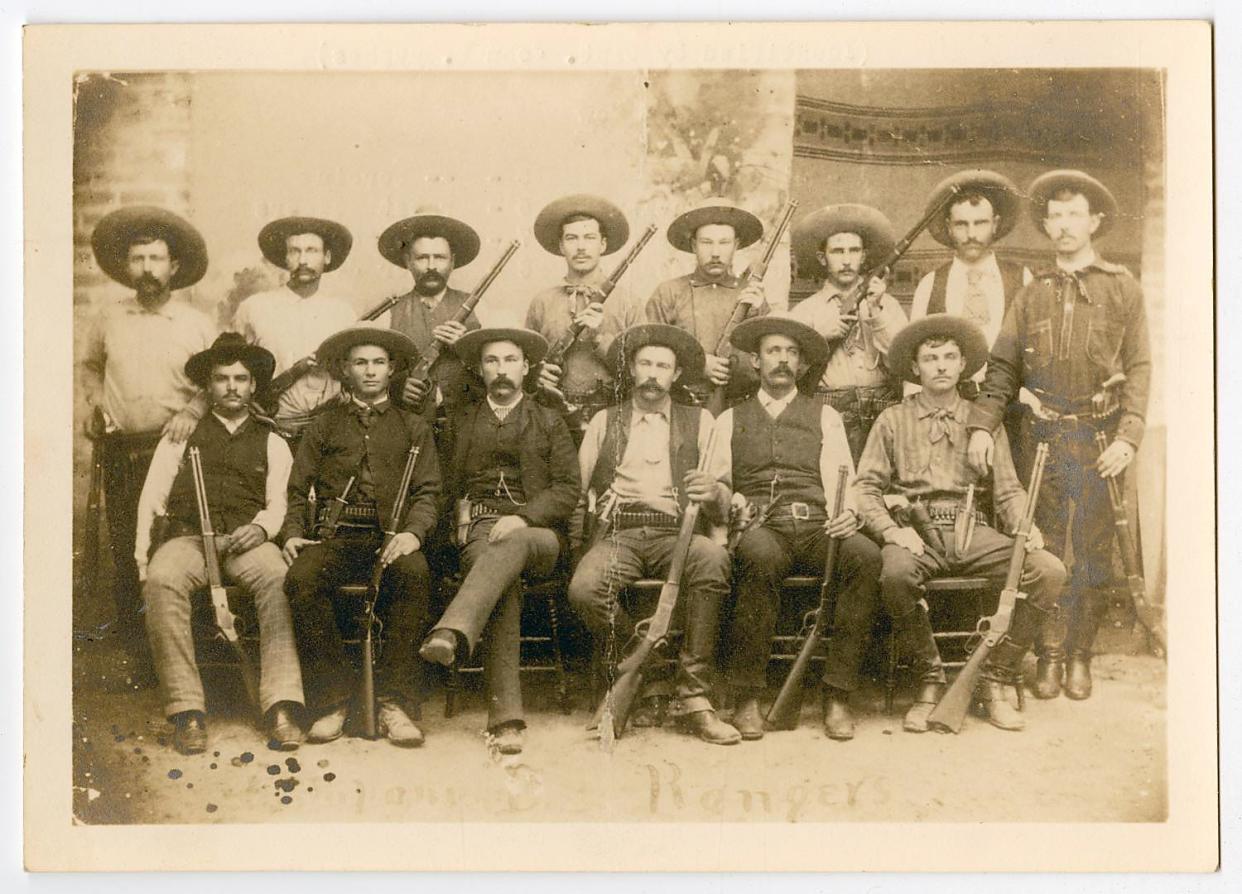 A group photo of Texas Rangers with their rifles, dated 1932 but likely older. Written on the back of the print were their names; on the top row at left are Jim King, Bass Outlaw, Riley Boston, Charles Fusselman, (No first Name) Derbin, Ernest Rodgers, Charles Barton, Walter Jones. Bottom row, at left, Bob Bell, Cal Aten, Captain Frank Jones, Walter Durbin, JIm Robinson, and Frank Schmidt.