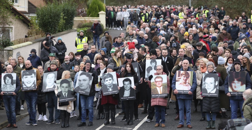 People take part in a march to commemorate the 50th anniversary of the 'Bloody Sunday' shootings with the photographs of some of the victims in Londonderry, Sunday, Jan. 30, 2022. In 1972 British soldiers shot 28 unarmed civilians at a civil rights march, killing 13 on what is known as Bloody Sunday or the Bogside Massacre. Sunday marks the 50th anniversary of the shootings in the Bogside area of Londonderry .(AP Photo/Peter Morrison)