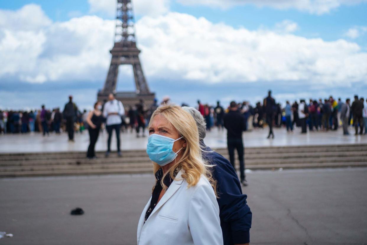 People wearing face masks stroll at Trocadero plaza near the Eiffel Tower, in Paris during the pandemic: AP