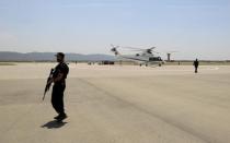 Security personnel stand guard as the helicopter carrying Pakistani Prime Minister Nawaz Sharif lands at the newly built airport in Islamabad, Pakistan May 6, 2017. REUTERS/Caren Firouz