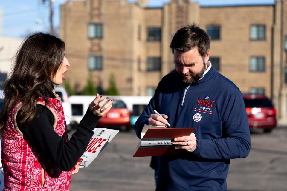 U.S. Senate candidate J.D. Vance speaks to a supporter while signing his book “Hillbilly Elegy” after voting in the 2022 midterm election in Cincinnati on Tuesday.