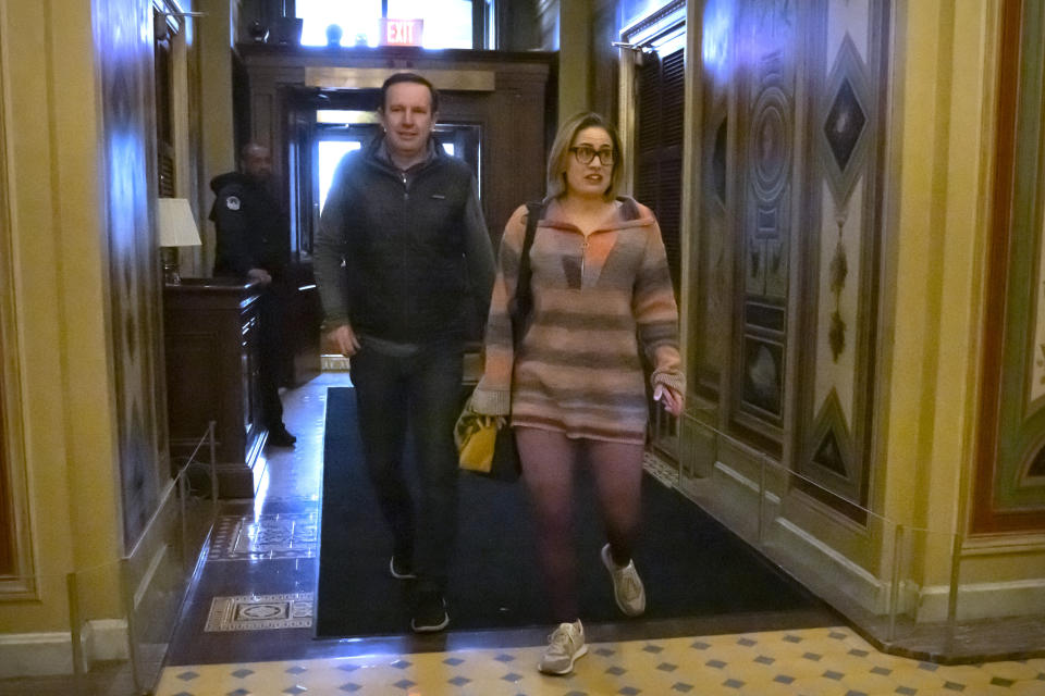 Sen. Chris Murphy, D-Conn., left, and Sen. Kyrsten Sinema, I-Ariz., right, arrive for closed-door negotiations on a border security deal at the Capitol, Sunday, Dec. 17, 2023, in Washington. Negotiators are rushing to reach a U.S. border security deal that would unlock President Joe Biden's request for billions of dollars worth in military aid for Ukraine and national security. (AP Photo/Mark Schiefelbein)