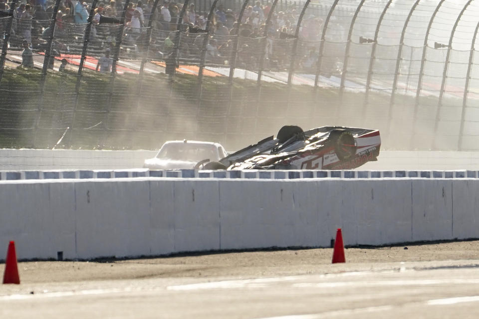 Another driver, left, makes his way past Jeb Burton as he slides upside down, down the straight during the NASCAR Xfinity Series auto race at Pocono Raceway, Saturday, July 23, 2022 in Long Pond, Pa. (AP Photo/Matt Slocum)