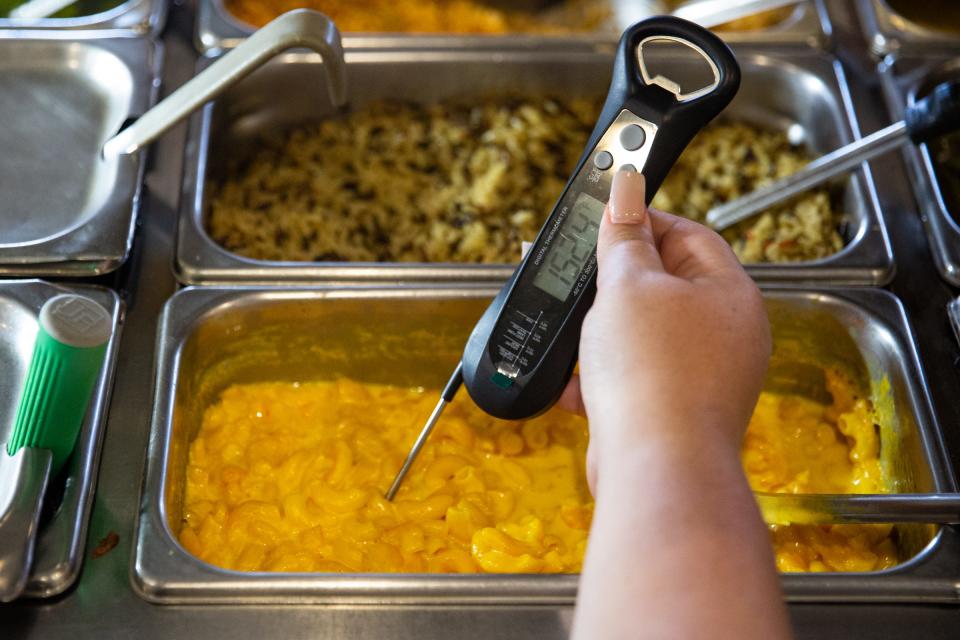 Joanie Garza, a public health inspector with the city, uses a thermometer to check the temperature of macaroni in warm holding during a restaurant inspection on June, 6 2023, in Corpus Christi, Texas.