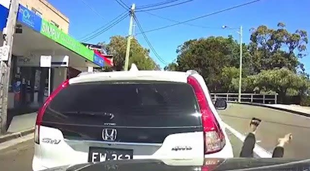 With the driver’s side door still open, the Honda sends the driver reeling backwards, flipping his legs in the air and sending one of his thongs flying off. Picture: Dash Cam Owners Australia Facebook