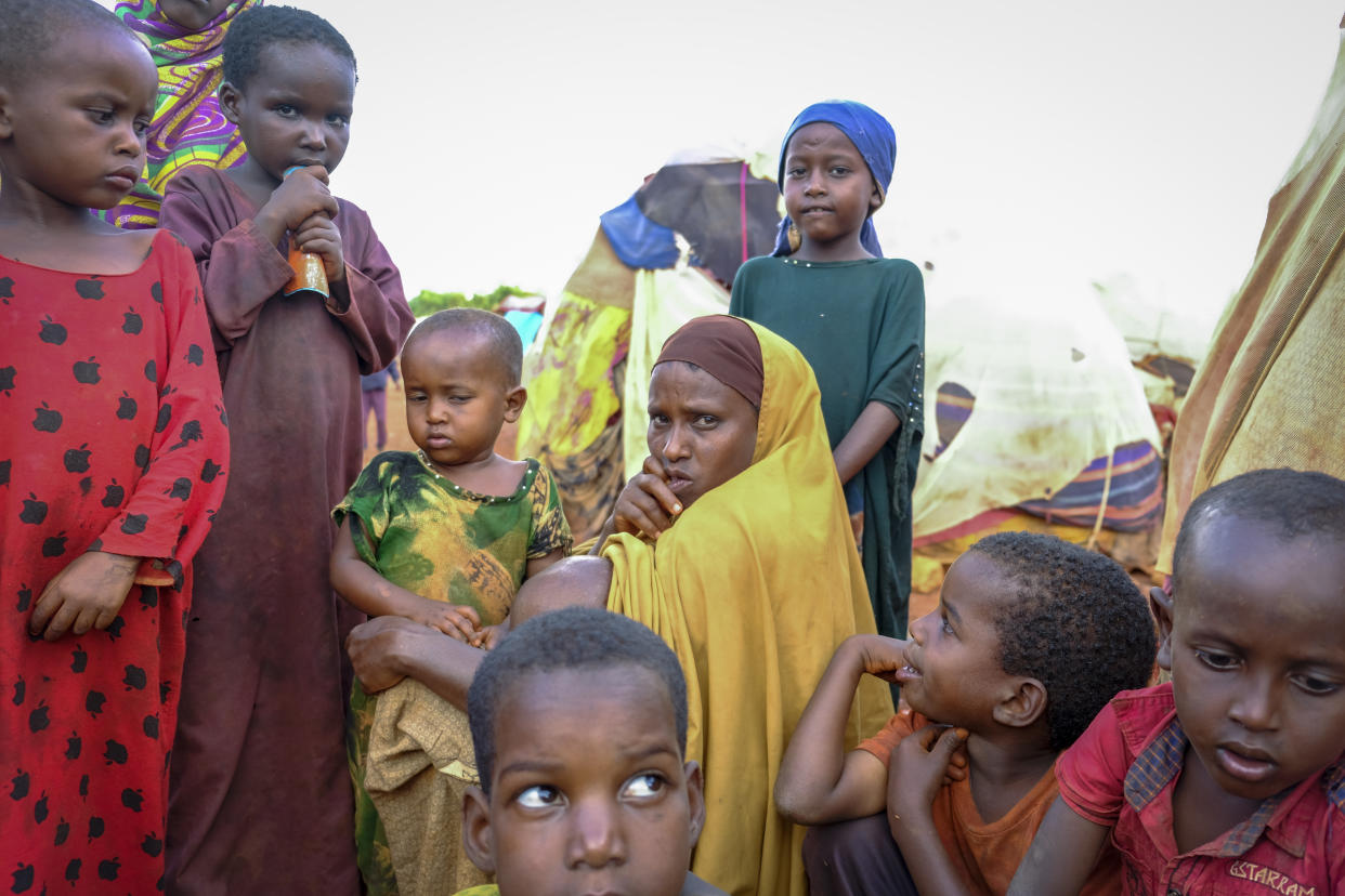 A mother and children displaced by drought sit outside their makeshift shelter on the outskirts of Baidoa, in Somalia Saturday, Oct. 29, 2022. Ships loaded with grain departed Ukraine on Tuesday, Nov. 1, 2022 despite Russia suspending its participation in a U.N.-brokered deal that ensures safe wartime passage of critical food supplies meant for parts of the world struggling with hunger such as Somalia. (AP Photo/Mohamed Sheikh Nor)