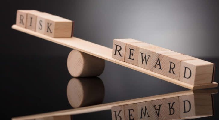 Two sets of blocks with the words "risk" and "reward" are placed on a seesaw with "reward" tipping downward.