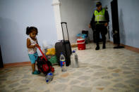 A child carries her belongings during a raid by Colombian authorities in which undocumented Venezuelans are deported to Venezuela, in Villa del Rosario, Colombia August 24, 2018. REUTERS/Carlos Garcia Rawlins