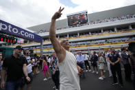 Vin Diesel salutes cheering spectators as he walks on the starting grid ahead of the Formula One Miami Grand Prix auto race, at Miami International Autodrome in Miami Gardens, Fla., Sunday, May 7, 2023. (AP Photo/Rebecca Blackwell)