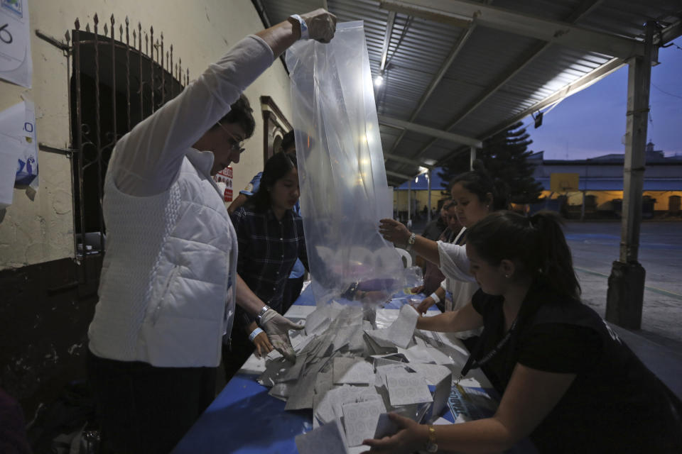 Election officials start counting votes after polling stations closed during general elections in Guatemala City, Sunday, June 16, 2019. Voters are choosing between 19 candidates for a four-year presidential term that begins in Jan. 2020. The winner needs an absolute majority, making an August runoff between the two top vote-getters likely. (AP Photo/Oliver De Ros)