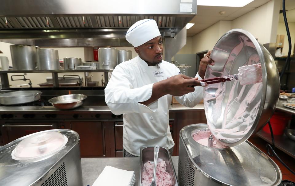Sullivan University student Eriq Young makes strawberry ice cream as they prepare a full course meal at the school in Louisville, Ky. on Apr. 23, 2023.  The Courier Journal donated decades of archived recipes to the university which is preparing a meal using those recipes to honor the past food editors.