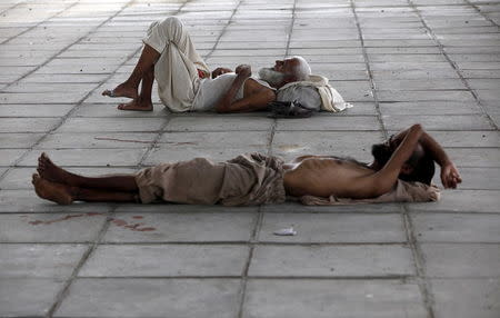 Men sleep in shade under a bridge during intense hot weather in Karachi, Pakistan, June 22, 2015. REUTERS/Akhtar Soomro -