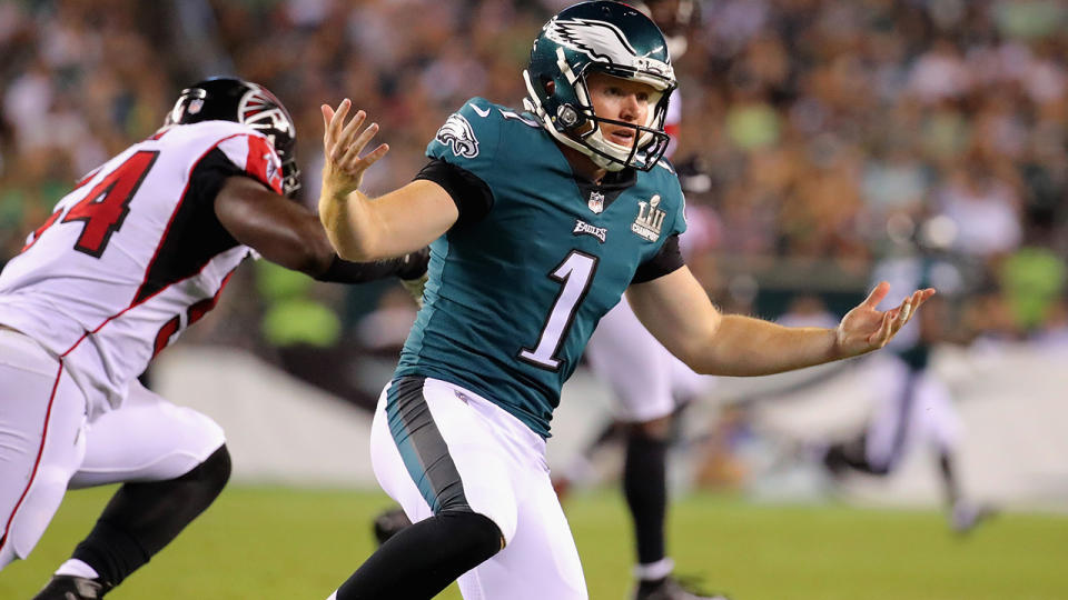 Cameron Johnston reacts after being hit by Foye Oluokun as he punted the ball. (Photo by Brett Carlsen/Getty Images)