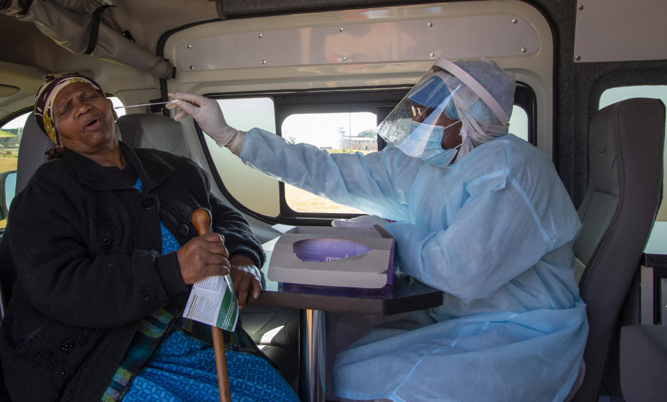 FILE - In this May 22, 2020, file photo, an elderly woman reacts as a heath worker collects a sample during the screening and testing campaign aimed to combat the spread of COVID-19 at Sphamandla, an informal settlement in Katlehong, south of Johannesburg, South Africa. The coronavirus pandemic has fractured global relationships, but John Nkengasong, Africa's top public health official, has helped to steer the continent's 54 countries into an alliance praised as responding better than some richer nations. (AP Photo/Themba Hadebe, File)