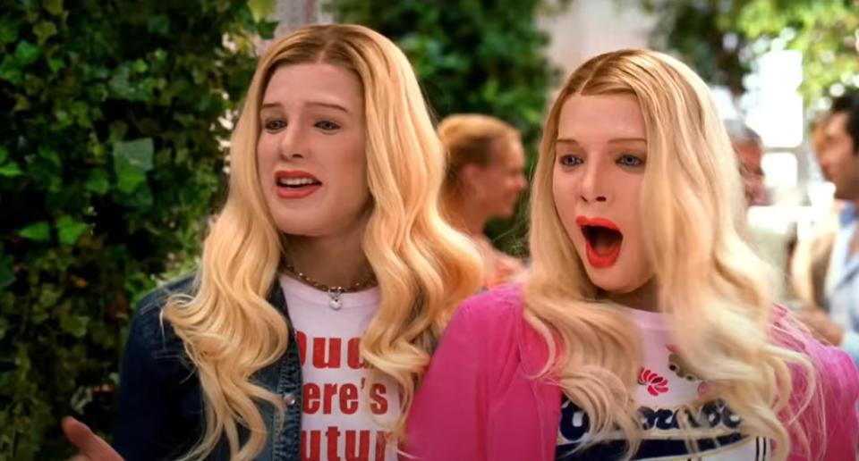 Marcus (Marlon Wayans) and Kevin Copeland (Shawn Wayans), dressed as two women with long blonde hair and open-mouthed expressions are standing outside with greenery in the background