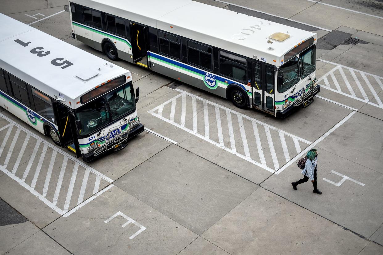 A passenger gets off a bus at the MSU-CATA Transportation Center on Wednesday, March 18, 2020, on the Michigan State University campus in East Lansing.