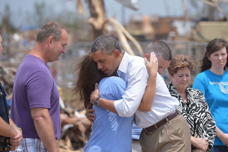 US President Barack Obama is greeted as he tours a tornado-affected area on May 26, 2013, in Moore, Oklahoma. Obama traveled to Oklahoma Sunday to view devastation from last week's monster tornado that killed 24 people, as the state's governor sought federal aid for thousands left destitute by the disaster