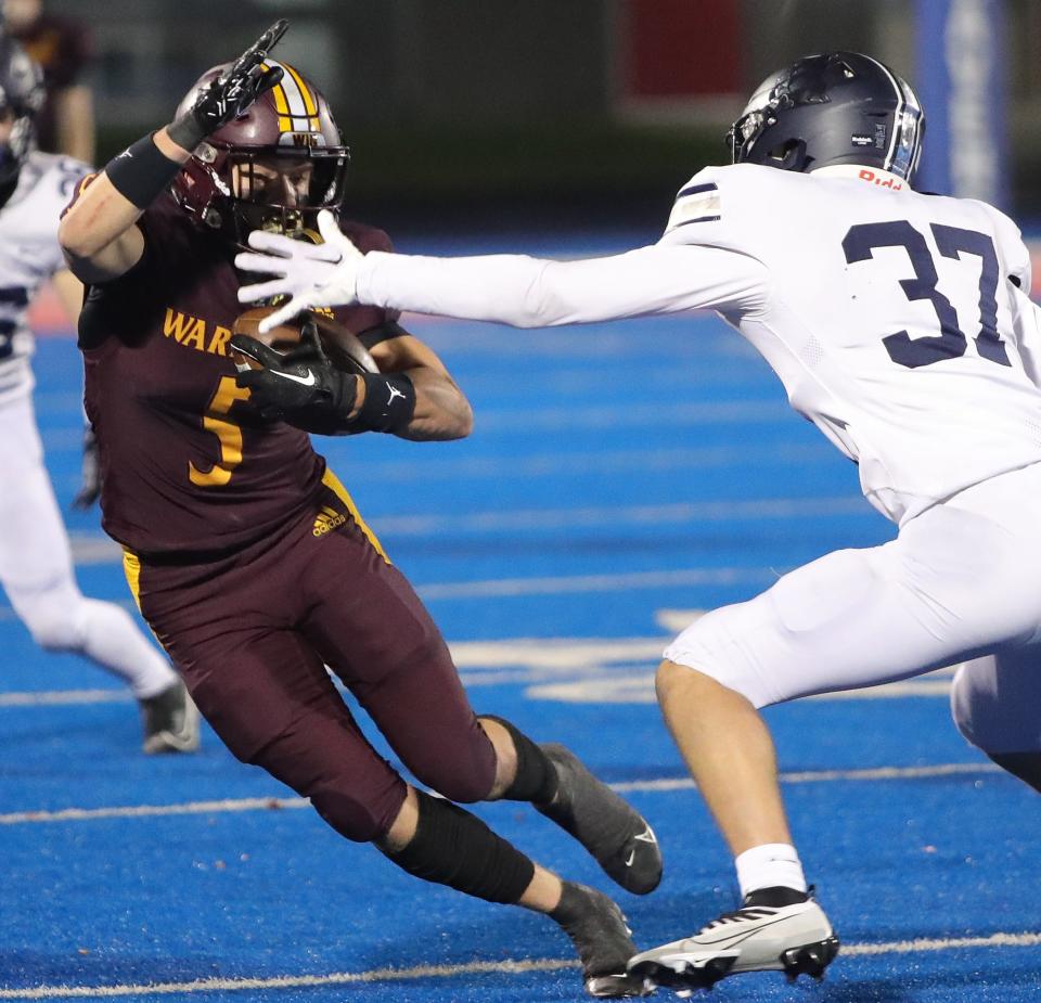 Walsh Jesuit's Aiden Henry tries to elude Hudson's Ian Robb during a regional semifinal Friday in Ravenna.