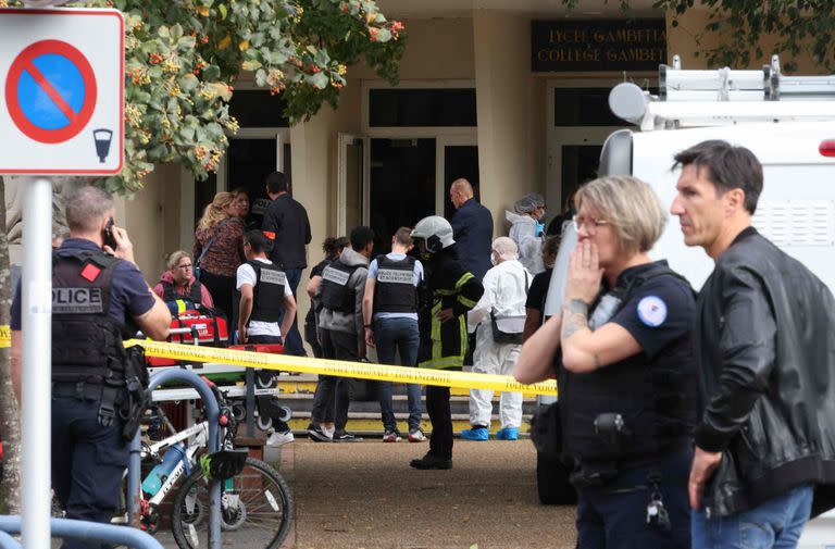 Agentes de policía franceses del servicio forense se encuentran frente a la escuela secundaria Gambetta en Arras, noreste de Francia, el 13 de octubre de 2023