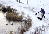 <p>A woman feeds the ducks on the Forth and Clyde canal in Helix Park, Falkirk, as heavy snow has caused more misery for travellers overnight, with the wintry weather disruption set to continue during the morning rush hour. (Andrew Milligan/PA Wire) </p>