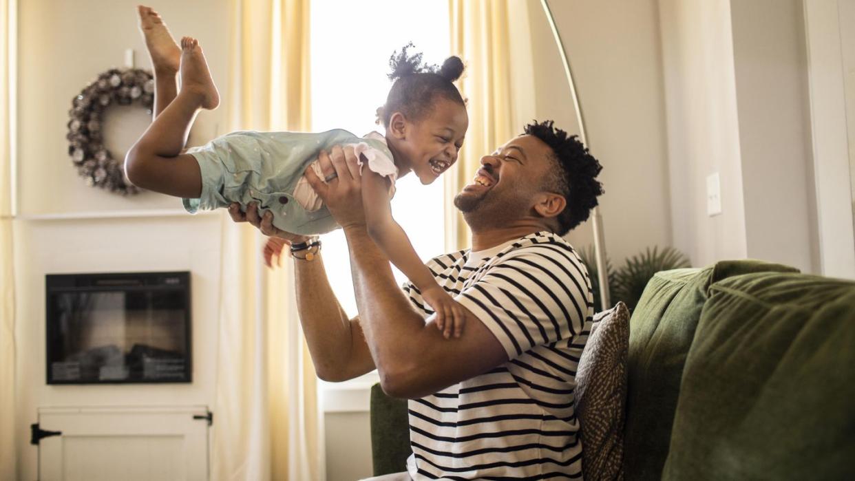 a happy father lifting his child up in the air