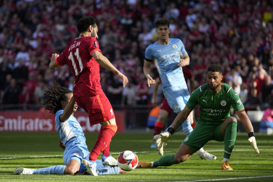Liverpool's Mohamed Salah, center, is challenged by Manchester City's Nathan Ake, left, and Manchester City's goalkeeper Zack Steffen during the English FA Cup semifinal soccer match between Manchester City and Liverpool at Wembley stadium in London, Saturday, April 16, 2022. (AP Photo/Frank Augstein)