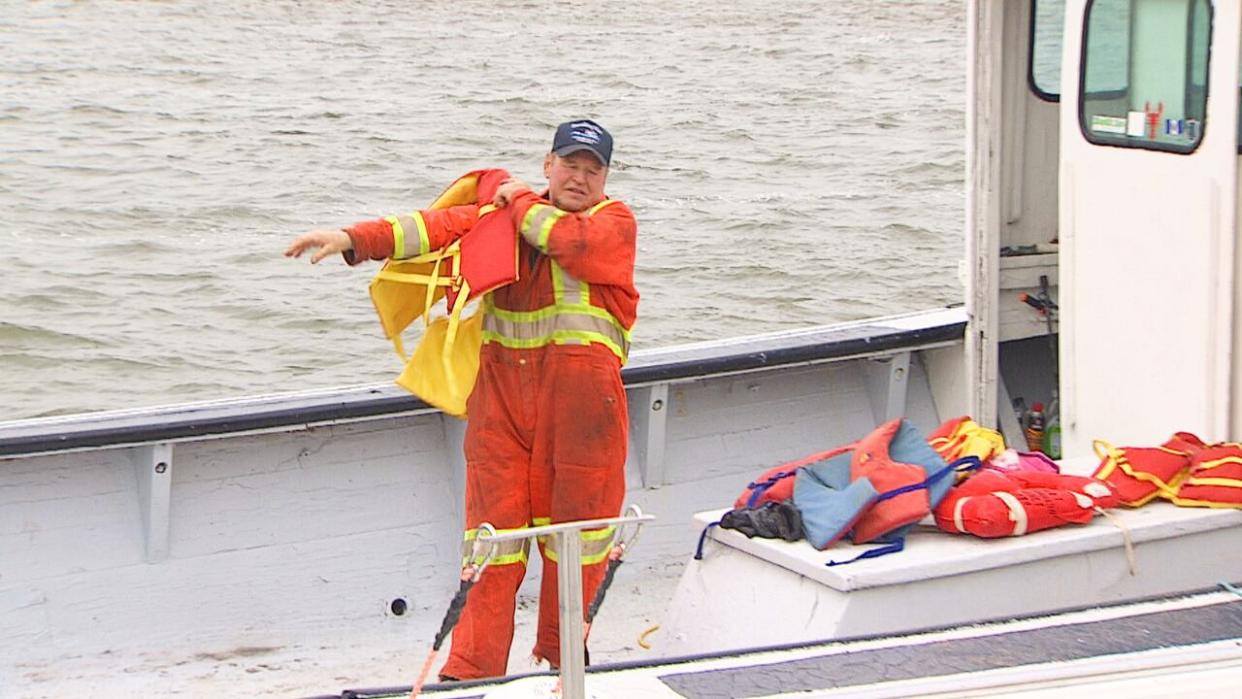 Allan Coady inspects the life-jackets on his fishing boat Friday in Covehead Harbour. (CBC - image credit)