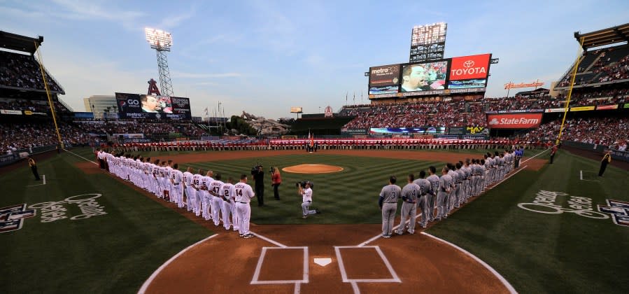 Teams line up during the national anthem at Angel Stadium prior to the Los Angeles Angels' baseball game against the Kansas City Royals, on Friday, April 6, 2012, in Anaheim, Calif. The mayor of the Southern California city of Anaheim is resigning amid a swirling political scandal over the sale of Angel Stadium to the baseball team. Mayor Harry Sidhu is quitting his post effective Tuesday, May 24, 2022, his lawyer, Paul S. Meyer, said in a statement Monday. He said the stadium negotiations were lawful and that Sidhu didn't ask for campaign contributions linked to the deal. (AP Photo/Mark J. Terrill, File)