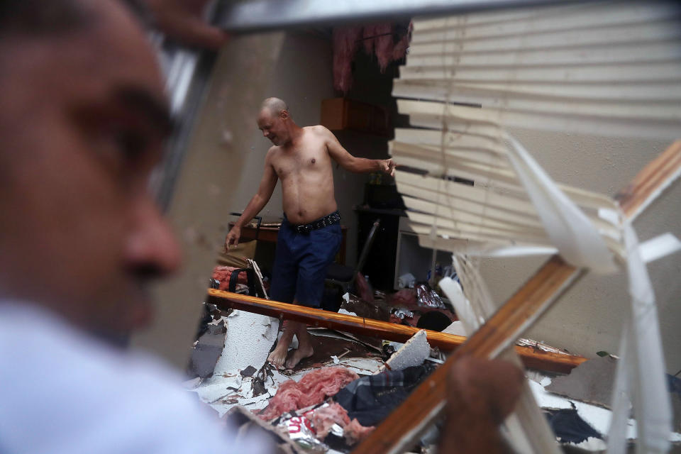 <p>Billy Raney makes his way to Lee Guerrero through the wreakage of his apartment after Hurricane Harvey destroyed it on August 26, 2017 in Rockport, Texas. (Photo: Joe Raedle/Getty Images) </p>