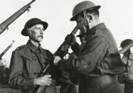 <p>A new recruit has his rifle inspected at a training camp in 1940. (Popperfoto/Getty Images)</p>