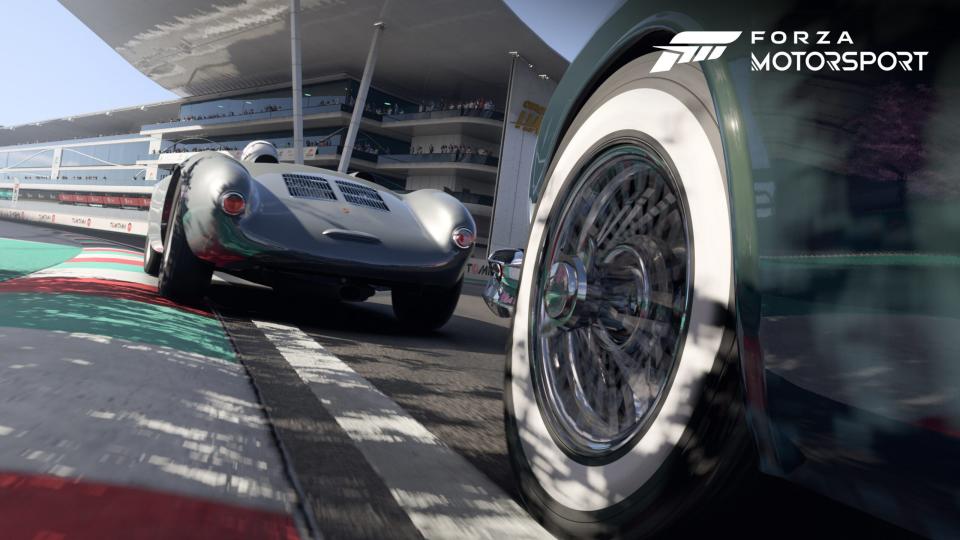View from front wheel and tire of a classic car race in a Forza Motorsport press image.