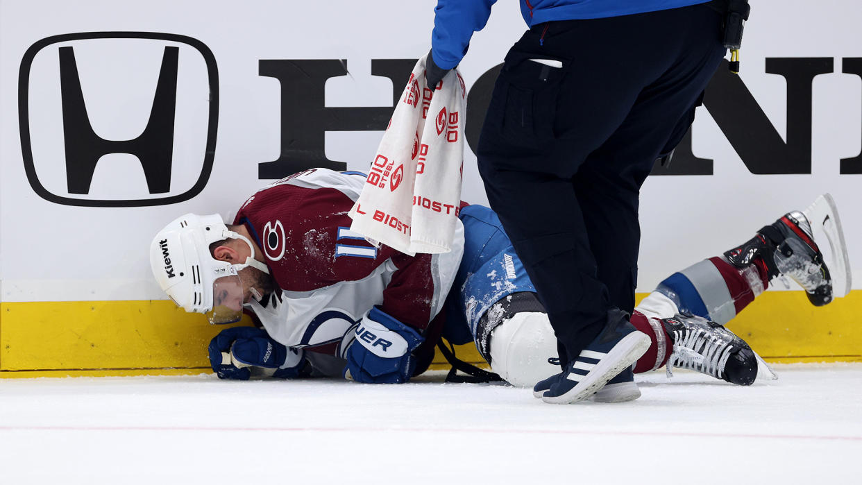 Andrew Cogliano of the Colorado Avalanche is tended to by medical staff. (Photo by Steph Chambers/Getty Images)