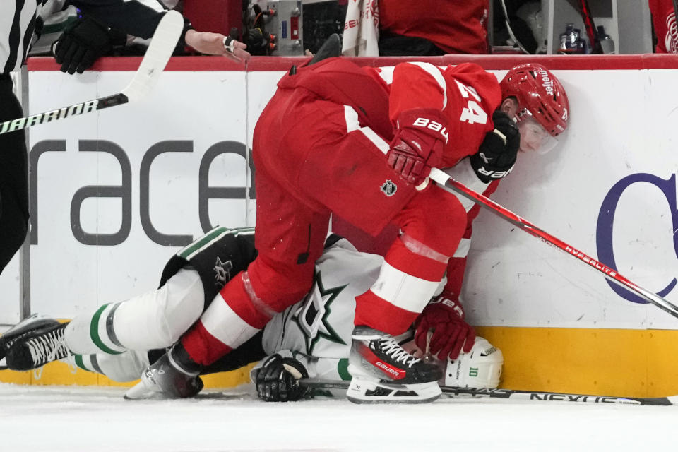 Detroit Red Wings center Klim Kostin (24) holds Dallas Stars center Ty Dellandrea (10) to the ice in the second period of an NHL hockey game Tuesday, Jan. 23, 2024, in Detroit. (AP Photo/Paul Sancya)