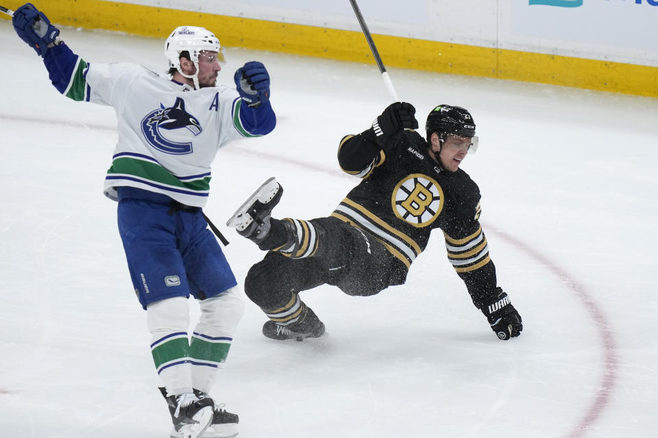 Vancouver Canucks center J.T. Miller, left, and Boston Bruins defenseman Hampus Lindholm, right, lose their balance after colliding during the first period of an NHL hockey game Thursday, Feb. 8, 2024, in Boston. (AP Photo/Steven Senne)